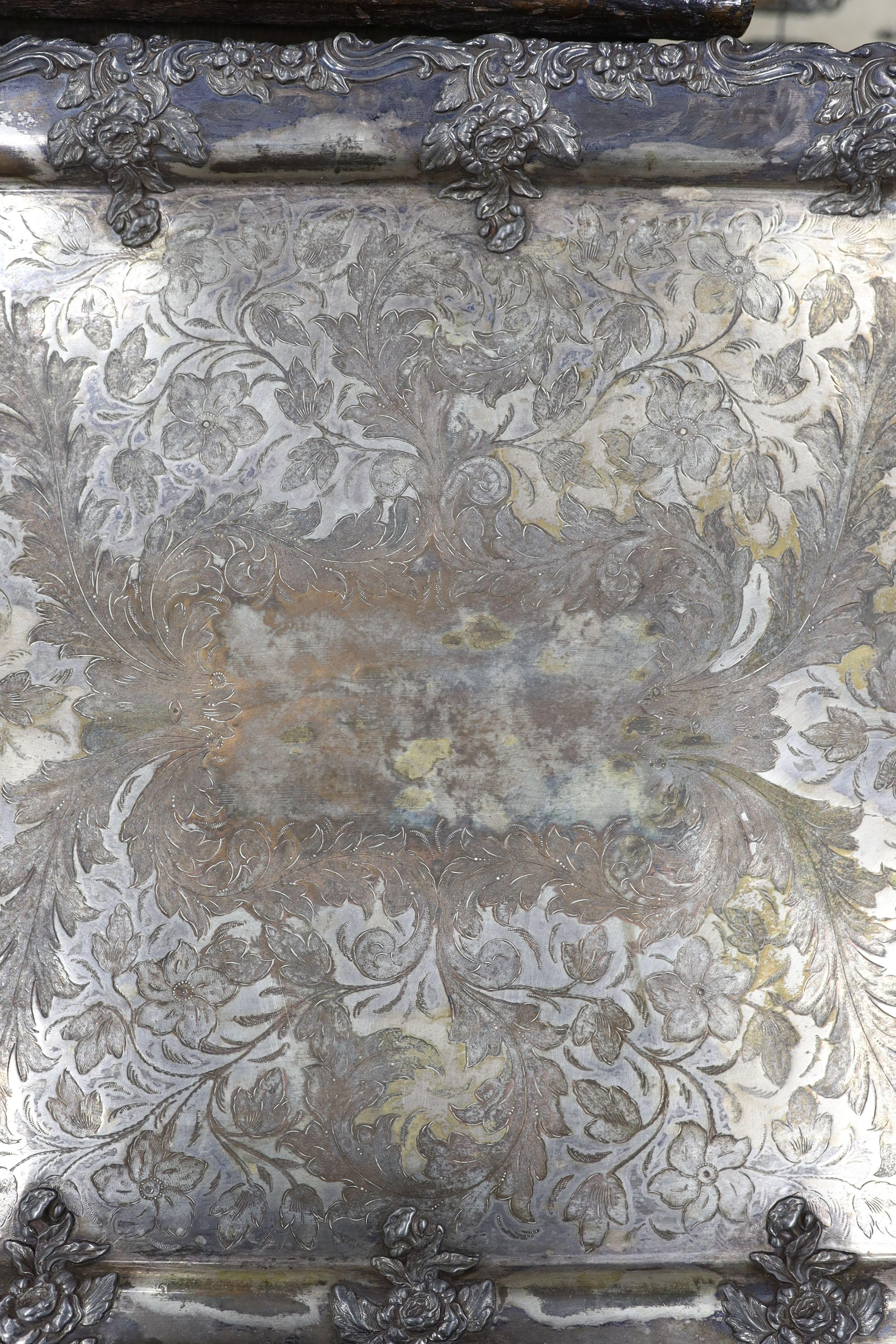 A large two handled silver plated tray with ornate floral edge, 87 cms wide.